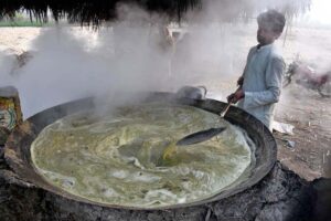 Farmer busy making traditional sweet item (Gurr) at his workplace