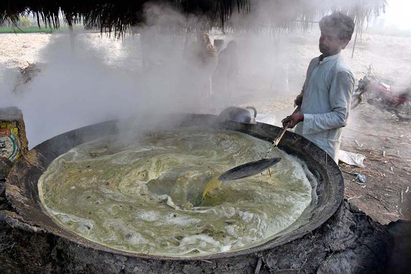 Farmer busy making traditional sweet item (Gurr) at his workplace