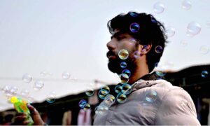 A woman vendor displaying balloons to attract the customers at Friday Bazaar, Peshawar Mor in Federal Capital