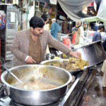 A vendor displaying and selling traditional food at Anarkali Bazar.
