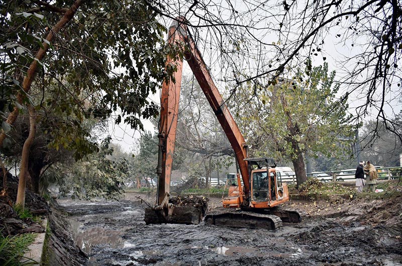 Workers busy in cleaning the Canal with the help of Machinery near Mall road in the Provincial Capital