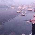 Youngster catching fish on the bank of river Gilgit.