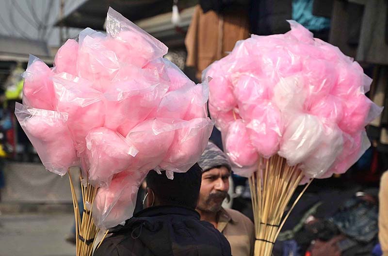 A woman vendor displaying balloons to attract the customers at Friday Bazaar, Peshawar Mor in Federal Capital