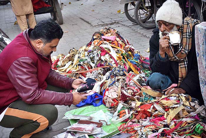 Elder vendor selling lace at his roadside setup.