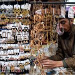 A vendor displaying artificial jewelry to attract the customers at Shahi Bazar.