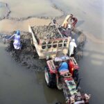 Labourers busy in loading sand on tractor trolley from Rice Canal