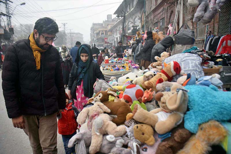 People selecting and purchasing old toys from vendor People selecting and purchasing old toys from vendor