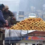Vendor is displaying and selling sweet items (GUR) to attract customers