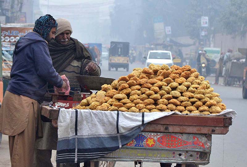 Vendor is displaying and selling sweet items (GUR) to attract customers