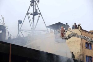 Rescue officials engage in fire extinguishing operation in Time Center mobile market at Saddar area