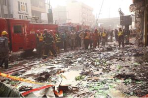 Rescue officials engage in fire extinguishing operation in Time Center mobile market at Saddar area