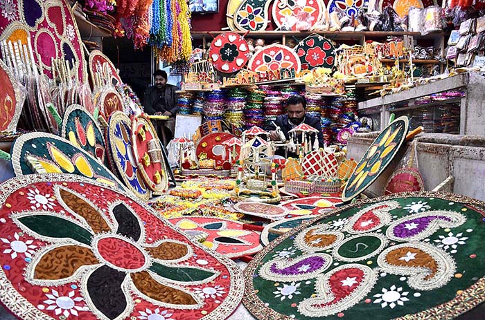 A vendor preparing the different kinds of decorative stuff using during marriage ceremonies at his workplace.