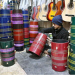 A vendor preparing the musical instrument drum (Dhoolke) for sale at his shop.