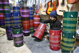 A vendor preparing the musical instrument drum (Dhoolke) for sale at his shop. 