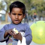 A gypsy child enjoying food item shuttling in the street at G-7 area