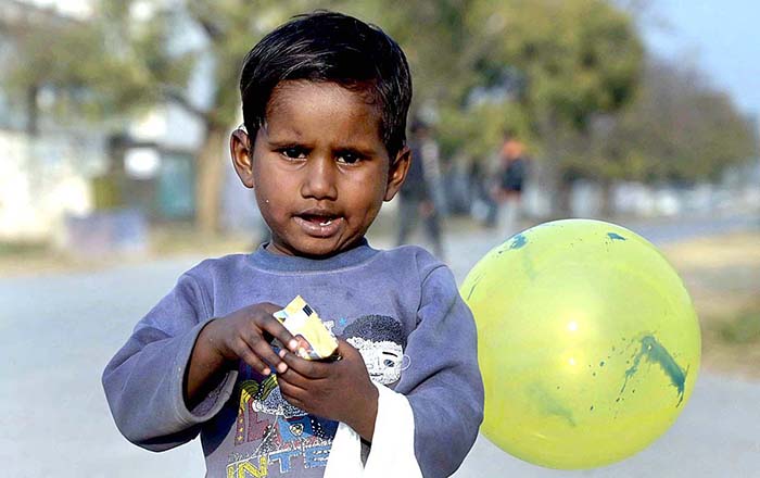 A gypsy child enjoying food item shuttling in the street at G-7 area