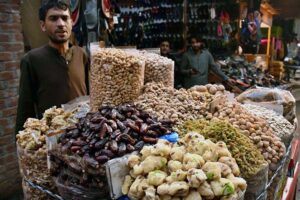 A vendor waiting for customers while displaying different kinds of Dry Fruits on the roadside setup at local market. 