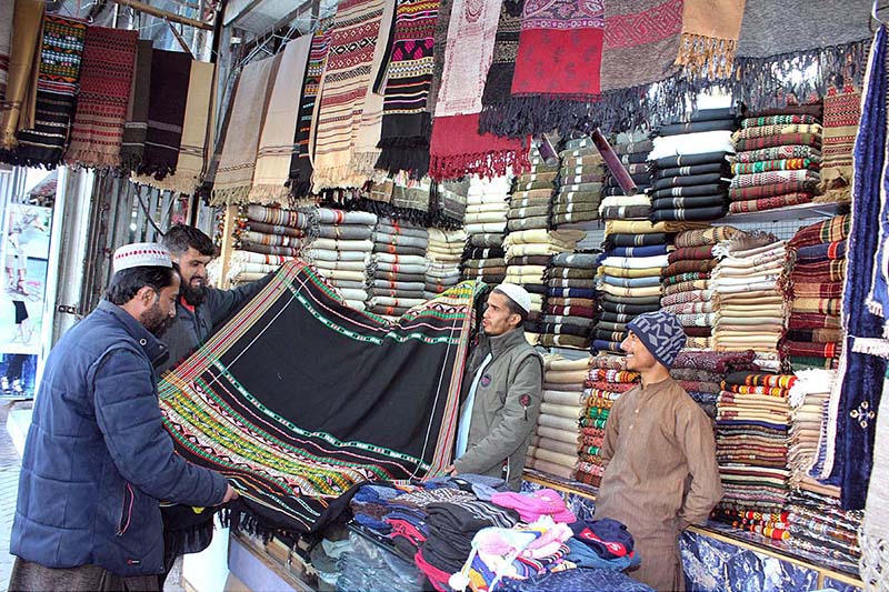 Man purchasing warm traditional shawl from vendor at Surajganj Bazaar Man purchasing warm traditional shawl from vendor at Surajganj Bazaar