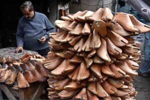 A whole seller displaying and selling the footwear wooden frames using for preparing shoes at local market