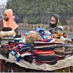 Women buying warm hats from the carriage near Data Darbar in view of the cold weather