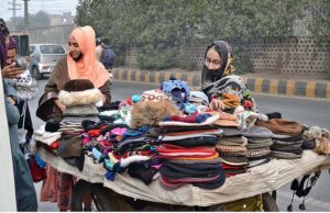 Women buying warm hats from the carriage near Data Darbar in view of the cold weather