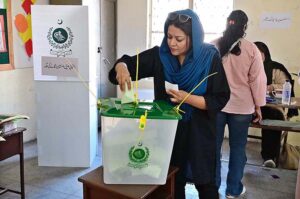 A woman casts her vote in the polling station during General Election-2024