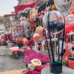Vendors displaying roses and flower bouquet to attract customers outside their shops at Bani Chowk.