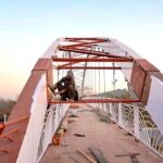 A welder finishing grills of a new pedestrian bridge over the Srinagar Highway in the federal capital.