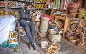 An artisan busy in preparing decorated baskets at his shop in Saddar. 