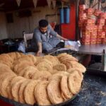 - A vendor selling traditional food item (Pheoni) at his setup.