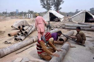 Workers busy welding iron pipe at IJP Road in the Federal Capital.