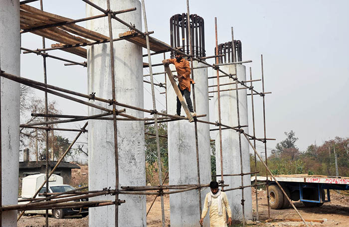 Labourers busy construction work of bridge at IJP Road in the Federal Capital.