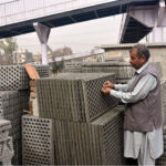Vendor busy displaying concrete drainage slabs at his setup in the Federal Capital.