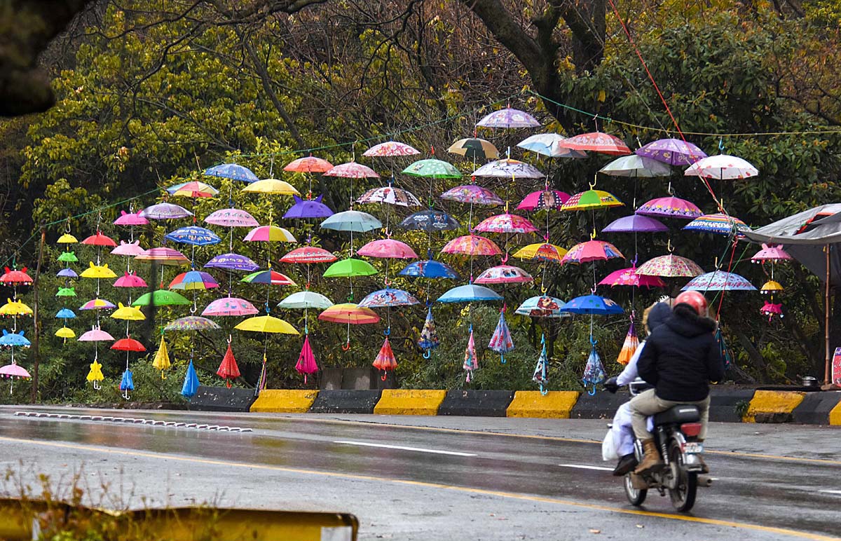 A vendor displaying colorful umbrellas at Satra Meel to attract the customers.