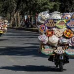 Street hawkers on the way carrying household items on motorcycles at F-7/2.