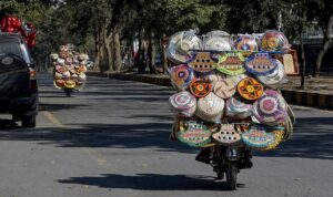 Street hawkers on the way carrying household items on motorcycles at F-7/2.