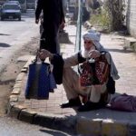 Elder vendor selling traditional children jackets at roadside in the Federal Capital.