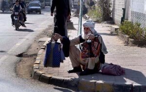 Elder vendor selling traditional children jackets at roadside in the Federal Capital.
