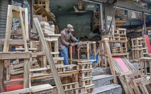 A carpenter busy in preparing wooden stools at his workplace in Banni Market. 