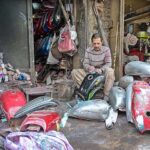 A worker is busy refurbishing the fuel tanks of motorcycles at his workplace in Bhabra Bazaar