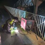 A welder busy in fixing a damaged pedestrian bridge on the Islamabad Expressway.