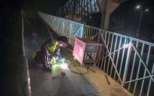 A welder busy in fixing a damaged pedestrian bridge on the Islamabad Expressway.