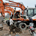 A mechanic reparse an excavator at his work place