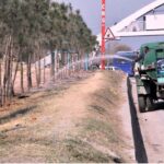 CDA worker busy in watering plants on green belts at Express way