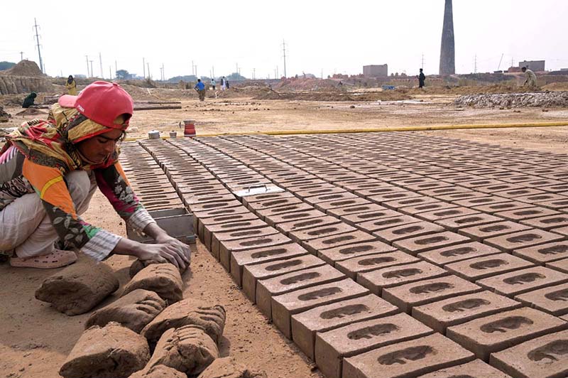 Woman Labourer busy preparing bricks at local bricks kiln