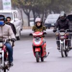 A girl on the way driving a Scooti on the Islamabad Expressway.
