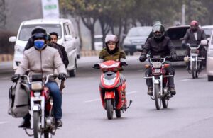 A girl on the way driving a Scooti on the Islamabad Expressway. 