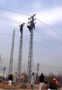 WAPDA workers busy installing new electricity cables on pylons at Chak Shahzad Road in the Federal Capital.