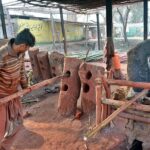 A worker busy in straightening a bamboo at Bhatta Chowk near Khushab Road.