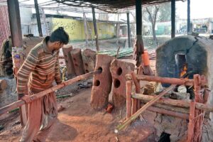 A worker busy in straightening a bamboo at Bhatta Chowk near Khushab Road.